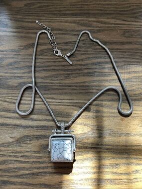 Silver-toned “freedom” necklace with reversible stone pendant.